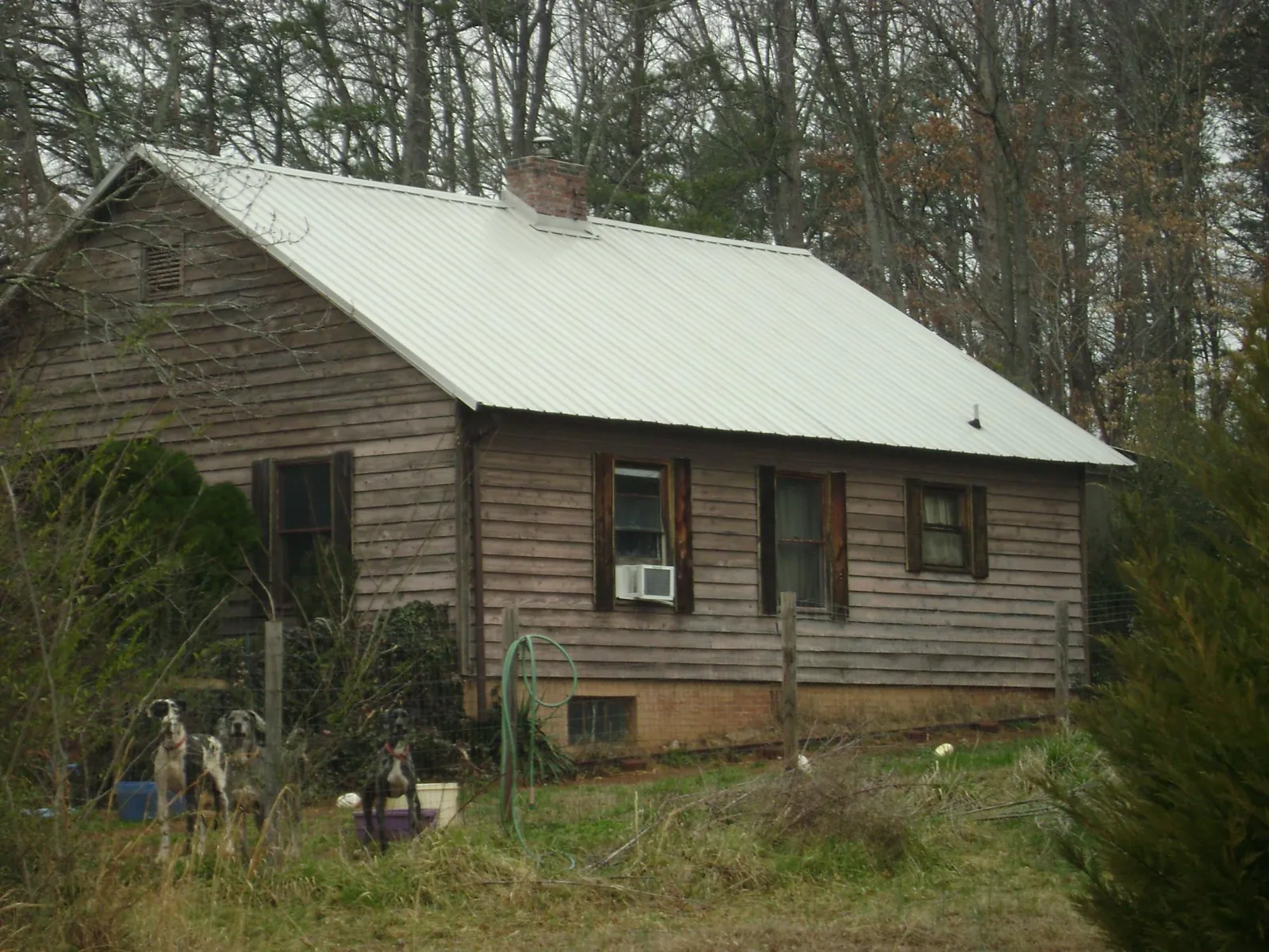 White metal roof on an old wood sided farmhouse, from a Metal Roof Installation job in Parkton